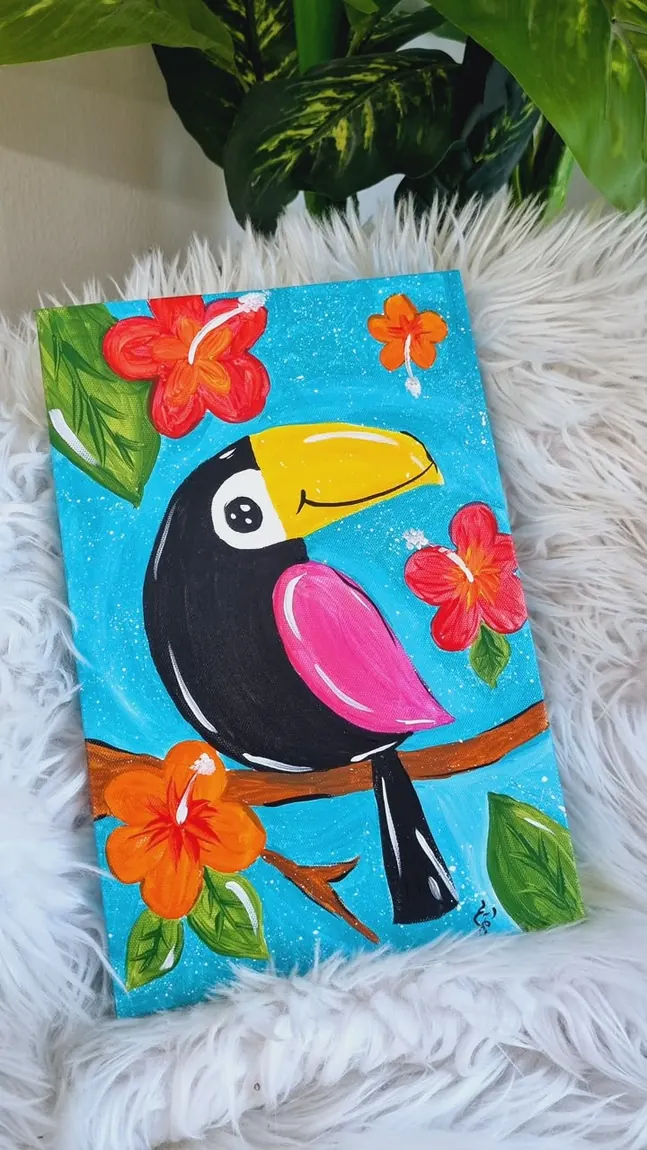 Cuadro terminado de un tucán entre flores tropicales sobre fondo turquesa.
